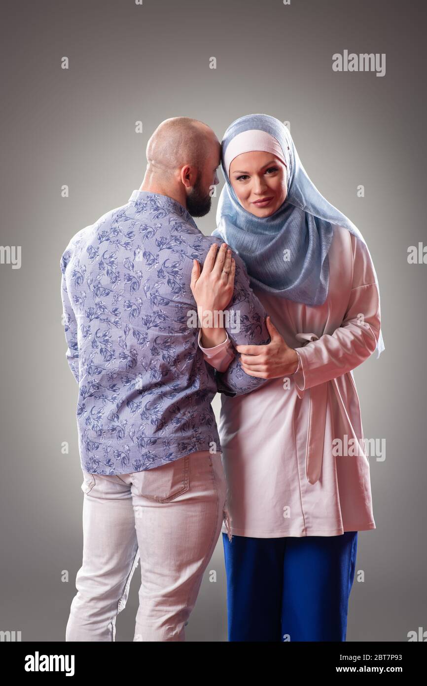 Glückliches Paar in der Liebe posiert auf dem grauen Hintergrund. Stockfoto