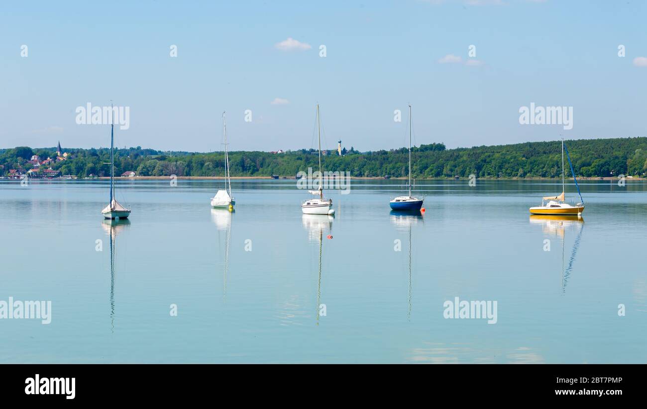 Panoramalandschaft mit ankenden Segelbooten. Farbenfrohe Aussicht auf den Ammersee. Symbol für Segeln, Segeln, Reichtum, Freizeitaktivitäten. Stockfoto