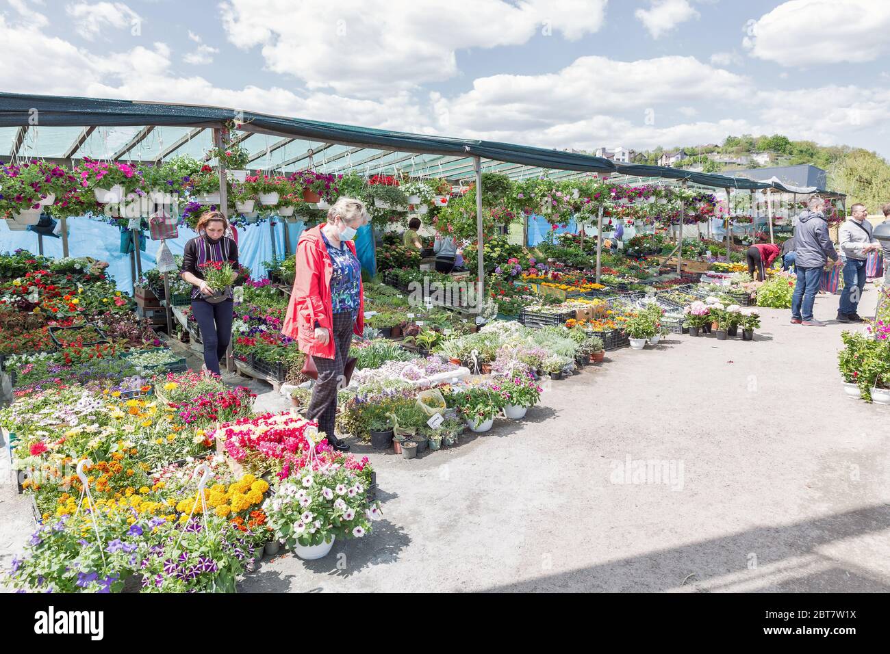 KIEW, UKRAINE - 09. MAI 2020: Menschen in medizinischen Masken besuchen Garten Blumen und Pflanzen Markt im Freien gerade nach COVID-19 Quarantäne Schwächung geöffnet. Stockfoto
