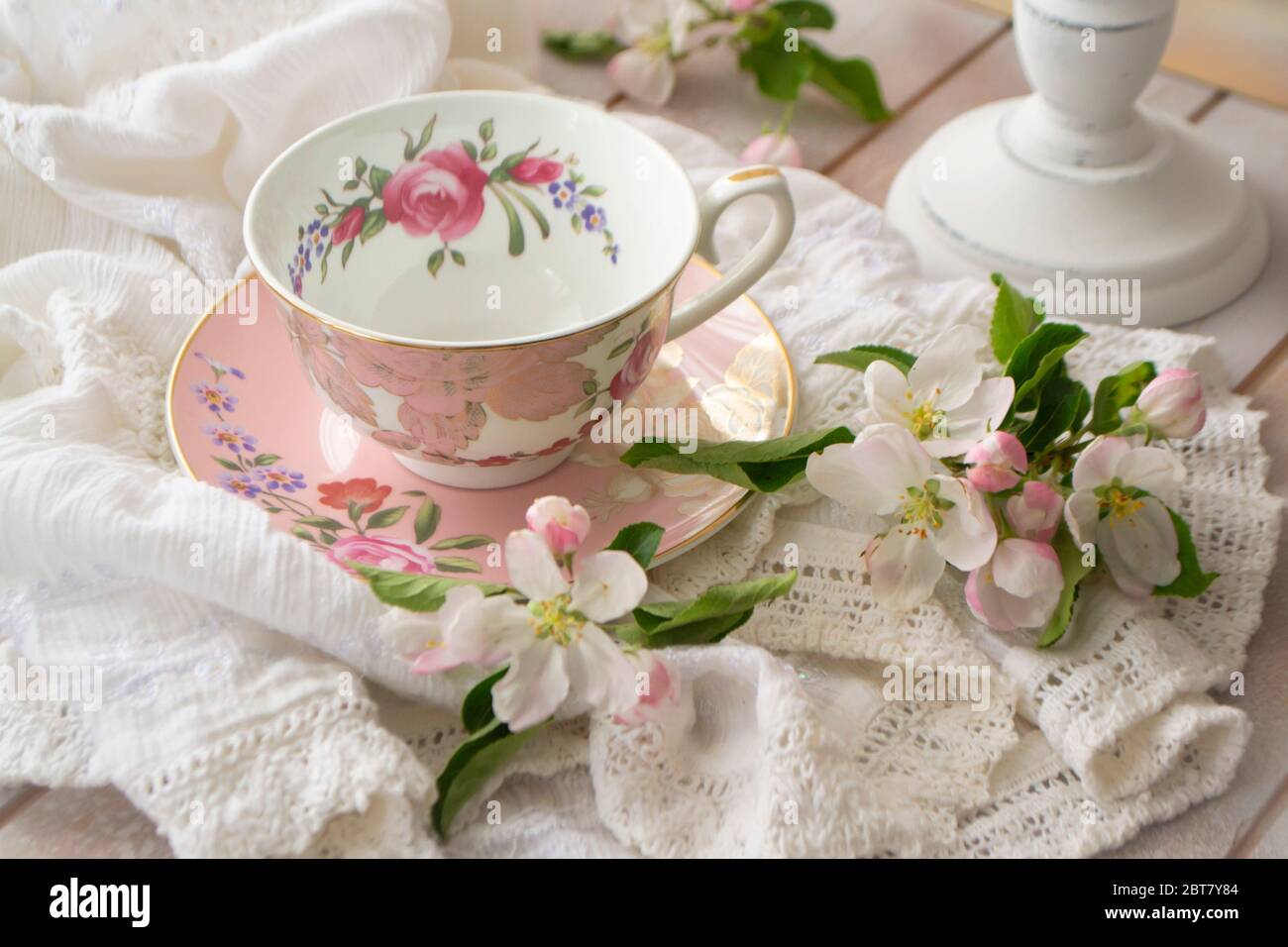 Rosa vintage Nachmittagstee Party, Tee Tasse und zarten Blumen auf Holztablett und Spitzen Tischdecke Stockfoto