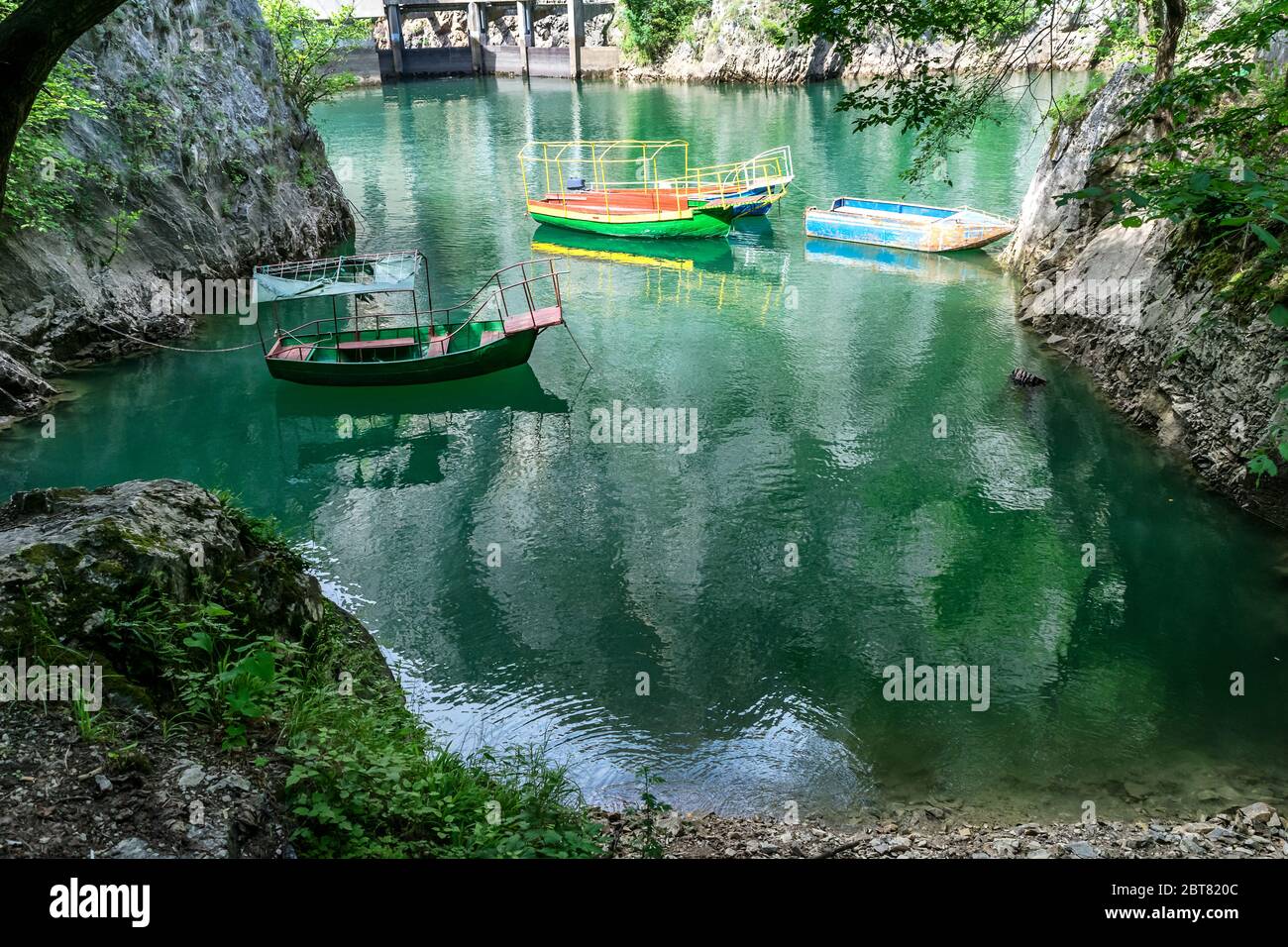 Alte schroffe und bunte Boote dockten in der kleinen Bucht am Matka Canyon, Skopje, Mazedonien Stockfoto