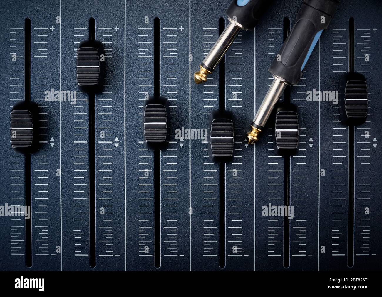 Audiokabel mit Klinkenbuchsen an Fadern eines Mischers für die Audioproduktion Stockfoto