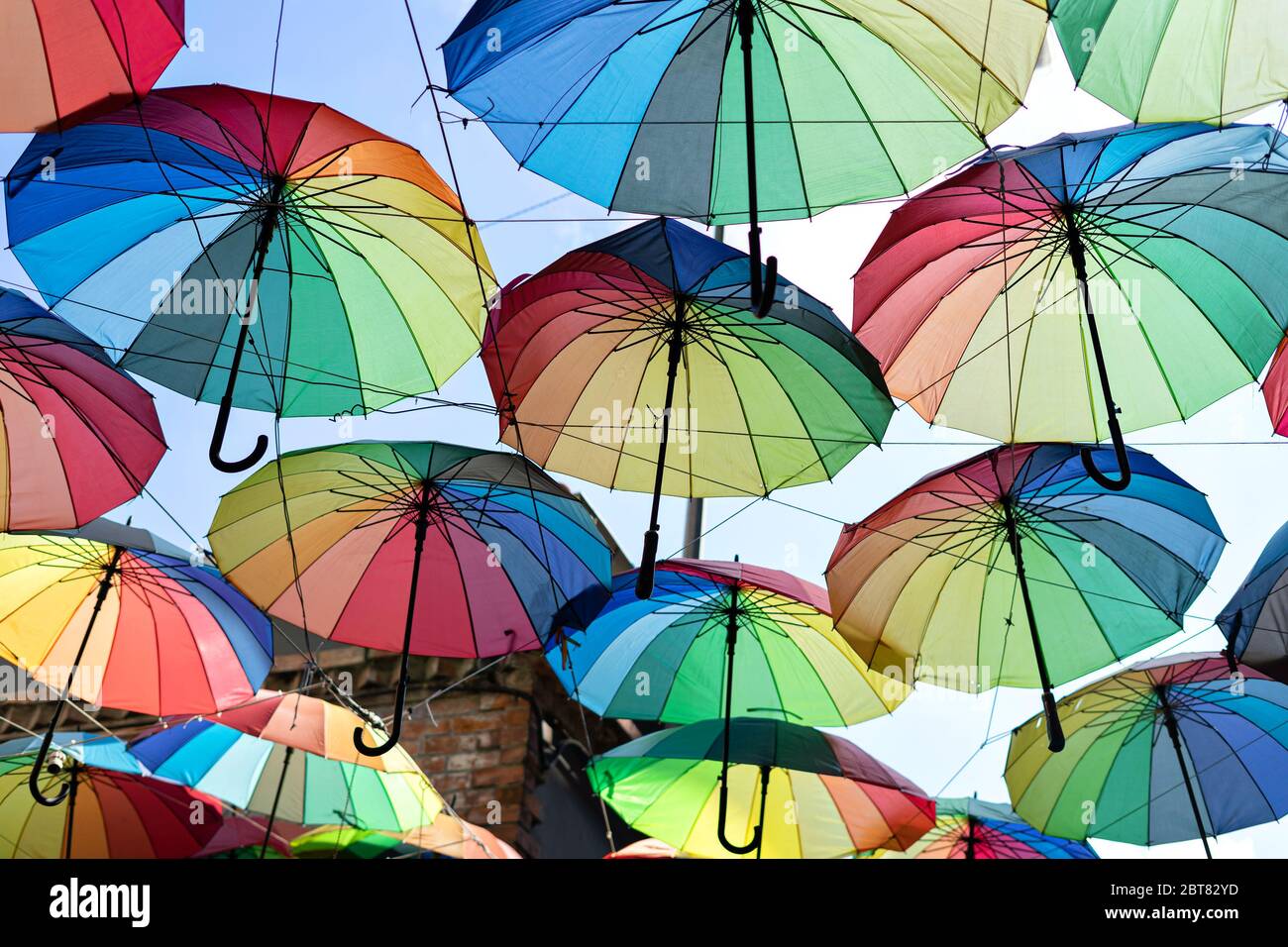 Hintergrund bunte Regenbogen verschiedene Farbe Regenschirme. Ungeban Tourist Straßendekoration. Stockfoto