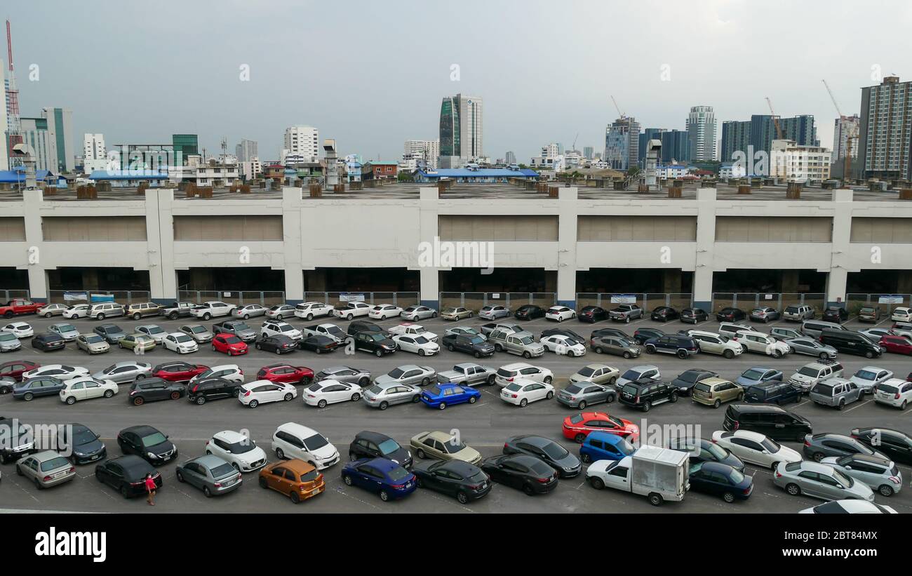 Bangkok, Thailand - 23. Mai 2020: Autos auf dem Außenparkplatz am BTS-Bahnhof Mo Chit geparkt, viele Gebäude im Hintergrund. Panoramaansicht. Stockfoto