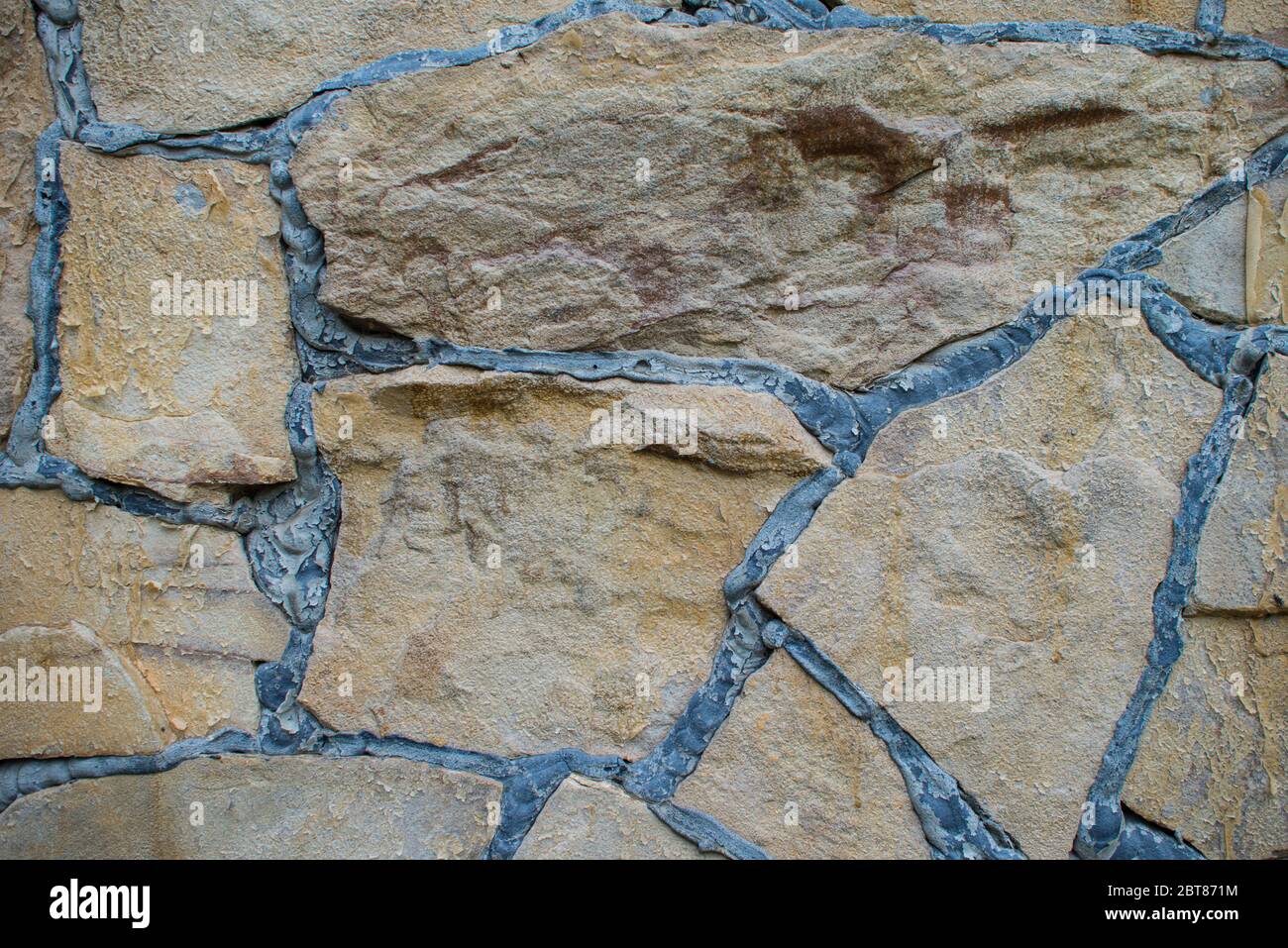 Natürliche braune Stein Block Pflasterung Textur. Steinwand mit schwarzen Nähten. Hintergrund erstellen Stockfoto