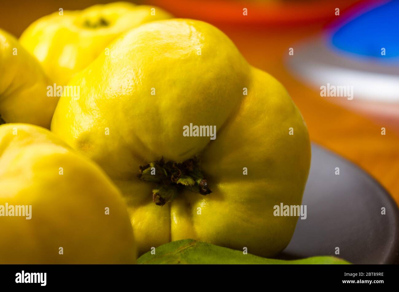 Große gelbe Quinzfrüchte auf einer Keramikplatte mit Anis, Zimt und Walnüssen Stockfoto