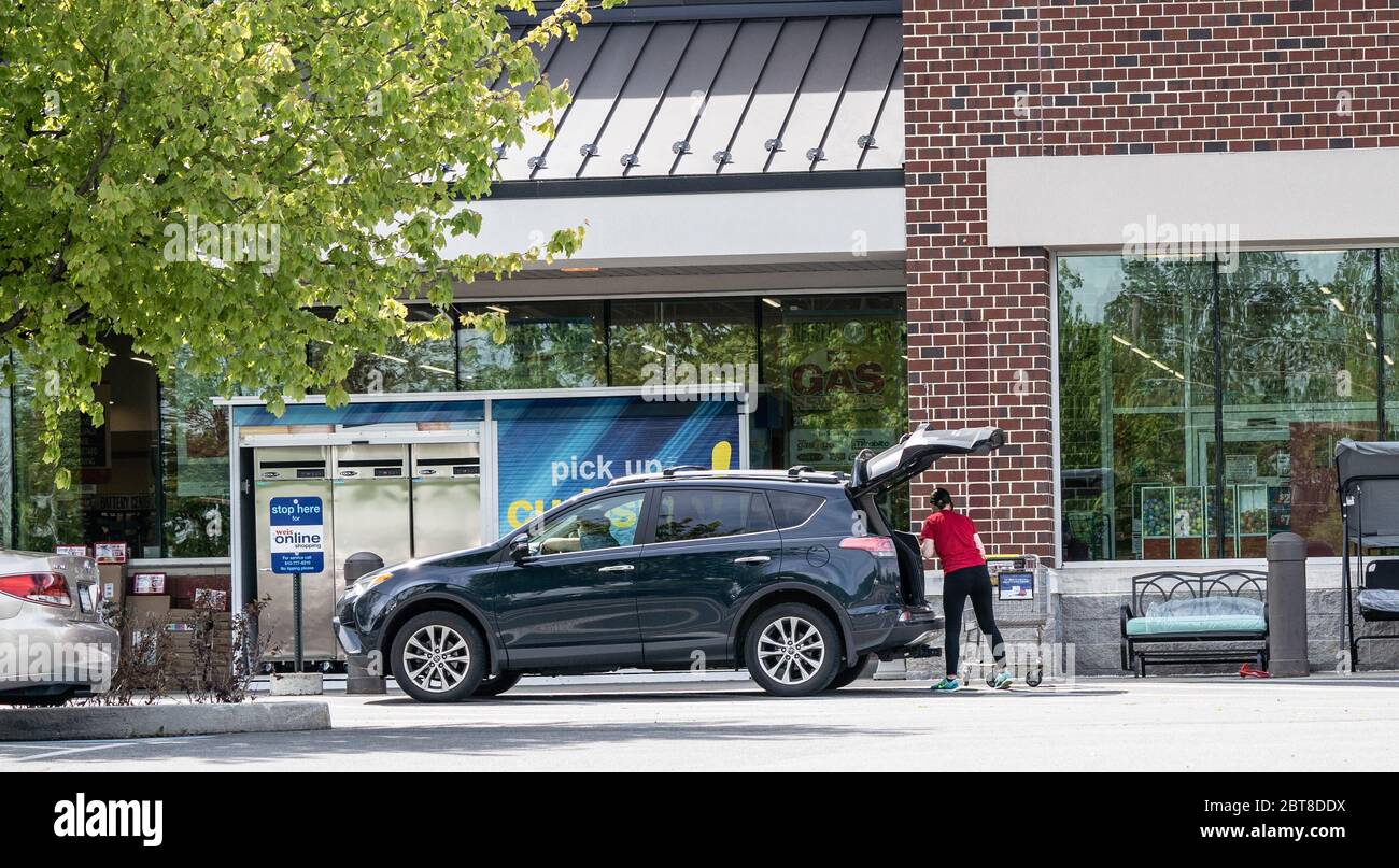 Berks County, Pennsylvania, USA - 19. Mai 2020: Mitarbeiter bringt Lebensmittel in Kunden Auto bei Weis Markets Bordsteinkante Pick-up. Stockfoto