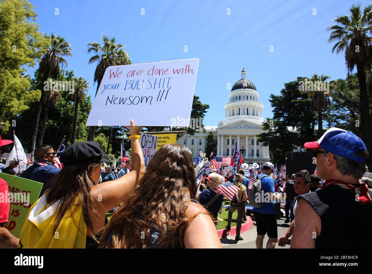 Ein Protestierender hält ein Plakat, das sagt, dass wir mit deiner BULLSHIT-Newsom während der Demonstration fertig sind.Demonstranten versammelten sich vor dem kalifornischen Kapitol, um gegen die kalifornischen Stay-at-Home-Befehle zu protestieren und für die Wiedereröffnung der kalifornischen Wirtschaft zu appellieren. Stockfoto