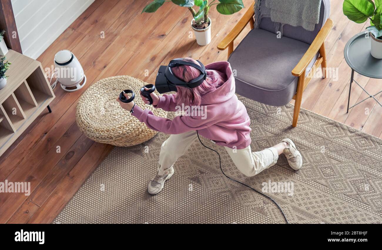 Teen Mädchen tragen vr Headset spielen Virtual Reality-Shooter-Spiel zu Hause, Draufsicht. Stockfoto
