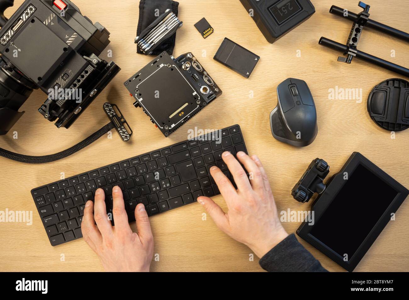 Die Hände wurden mit der Computertastatur durch verschiedene Geräte am Tisch abgeschnitten Stockfoto