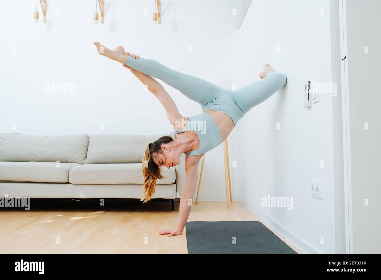 Das Mädchen in guter Ausbildung arrangiert ein Heim-Workout auf Akrobatik Stockfoto