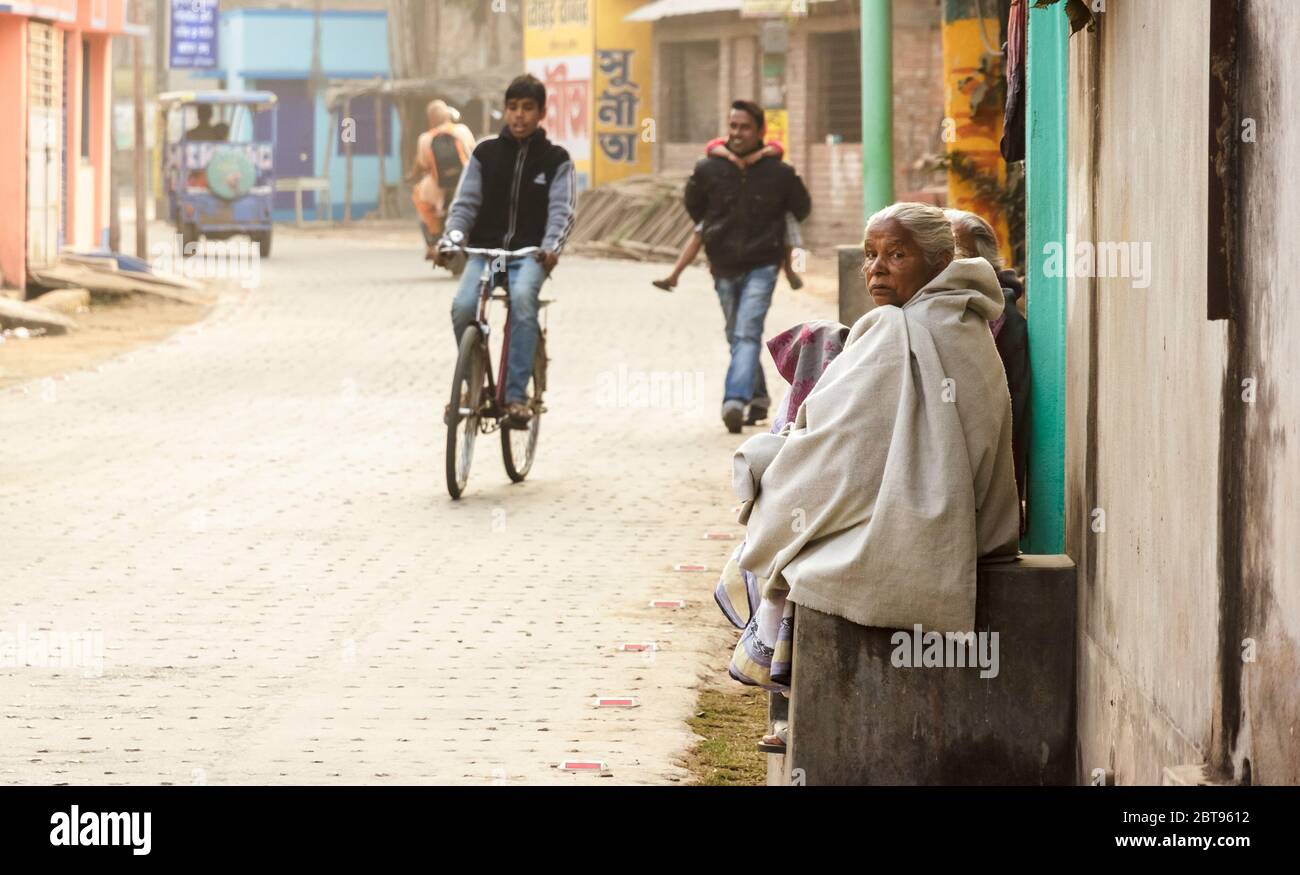 Murshidabad, Westbengalen/Indien - Januar 16 2018: Straßenporträt einer Frau, die auf einer Veranda vor ihrem Haus in den Straßen von Murshidabad sitzt. Stockfoto
