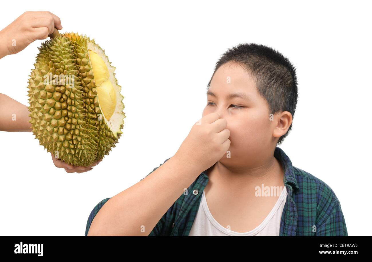Fettleibiger fetter Junge mit Ausdruck von Ekel gegen frische Durian isoliert auf weißem Hintergrund, Durian Frucht ist so stinkend und scharf, guter Geschmack, aber schlecht Stockfoto