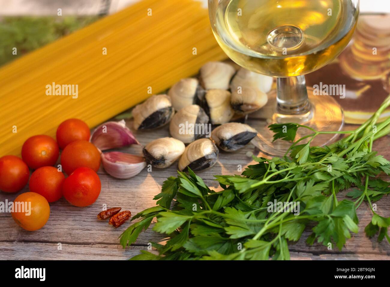 Zutaten für Spaghetti alle vongole, ein traditionelles italienisches Rezept: Spaghettis, Venusmuscheln, Tomaten, Knoblauch, Chili, Petersilie und Weißwein Stockfoto