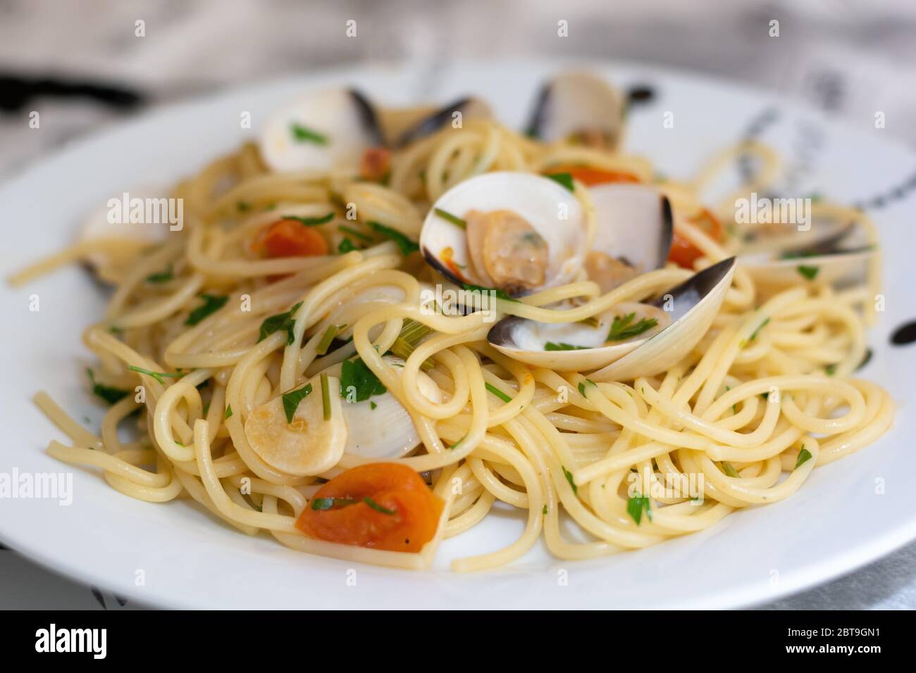 Spaghetti alle vongole, ein traditionelles italienisches Rezept mit Spaghettis, Venusmuscheln, Tomaten, Knoblauch, Chili, Petersilie und Weißwein Stockfoto