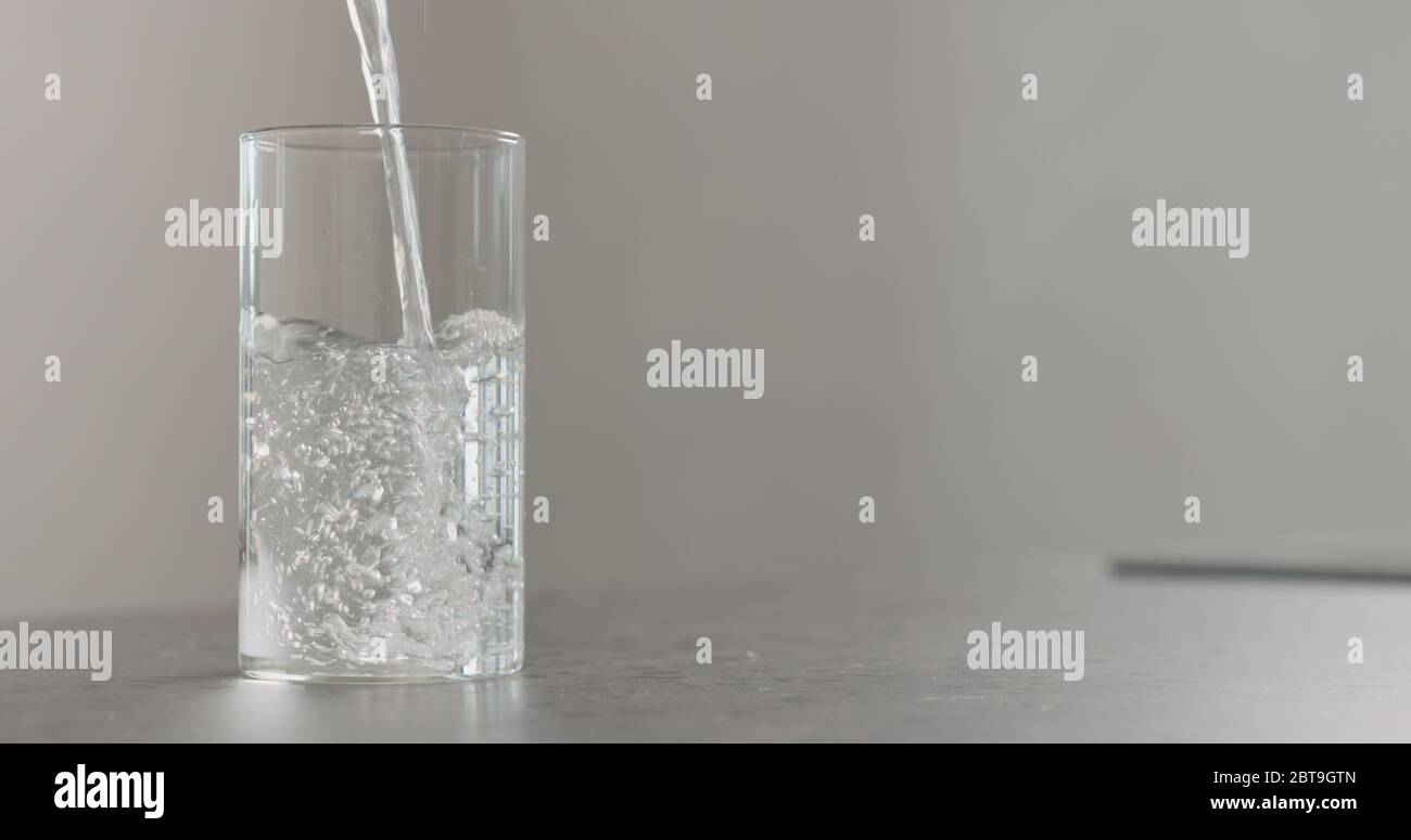 Frisches Wasser in das Becherglas auf die Arbeitsplatte gießen Stockfoto