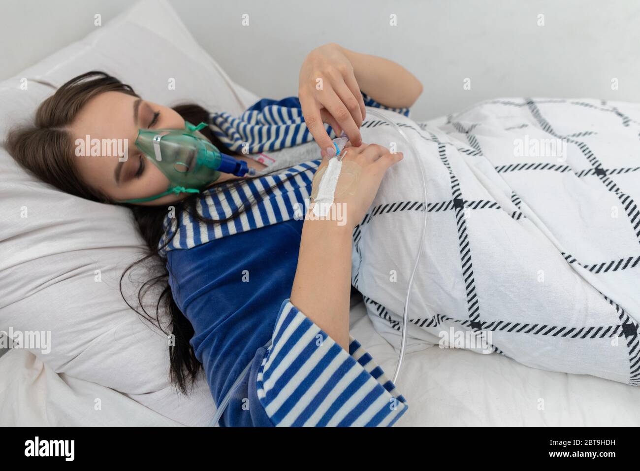 Sauerstoffmaske An Den Atemwegen Der Teenager Liegt In Einem Krankenhausbett Ein Schwer Kranke Junge Madchen Stockfotografie Alamy