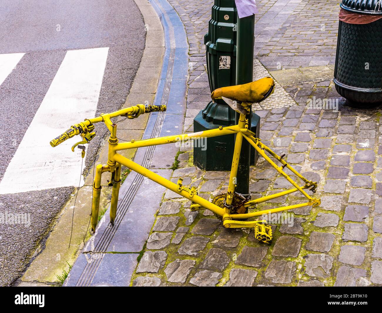 Verlassene und ausgefahrene Fahrrad an Lampe-Pfosten befestigt - Brüssel, Belgien. Stockfoto