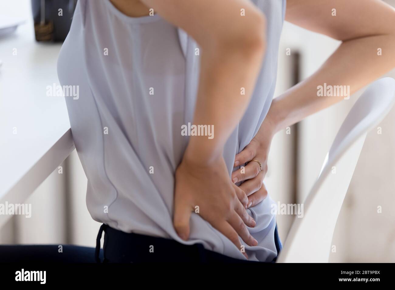 Nahaufnahme der weiblichen Mitarbeiterin leiden an Rückenschmerzen Stockfoto