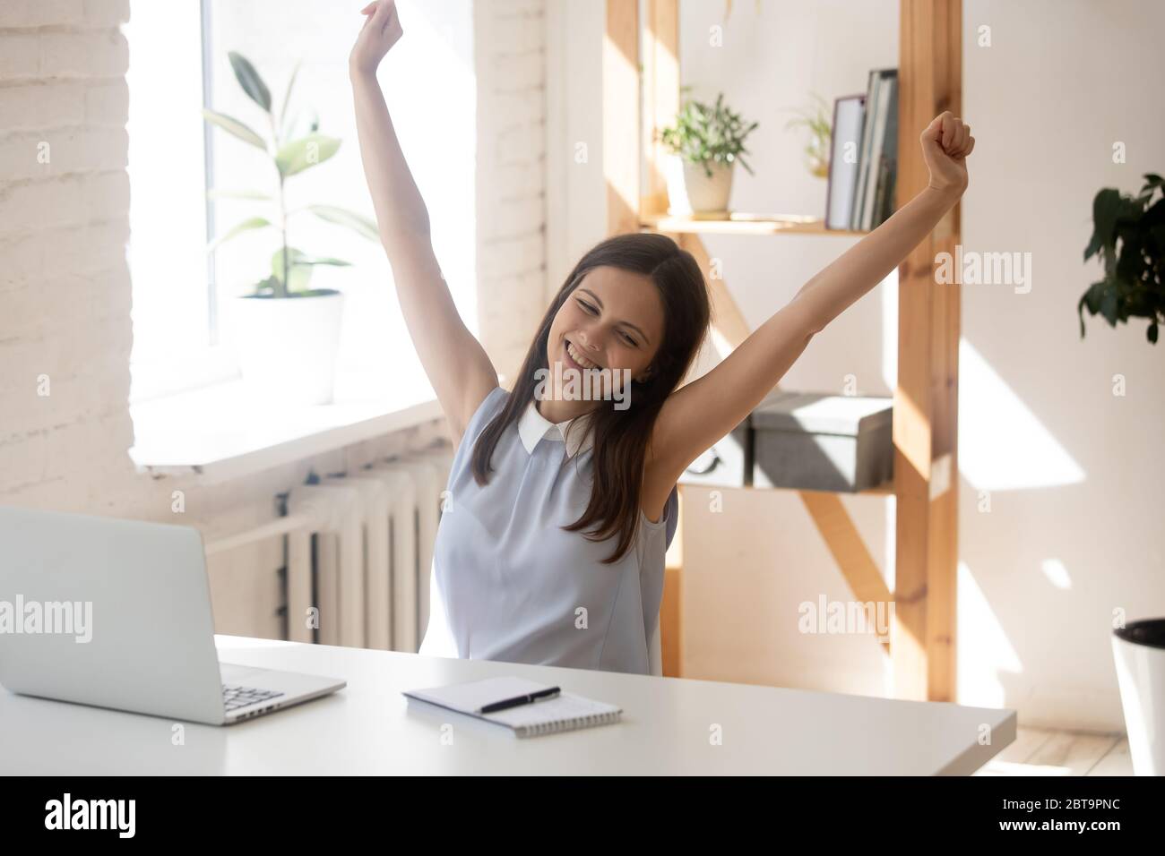 Glückliche weibliche Mitarbeiter Dehnübung am Arbeitsplatz Stockfoto