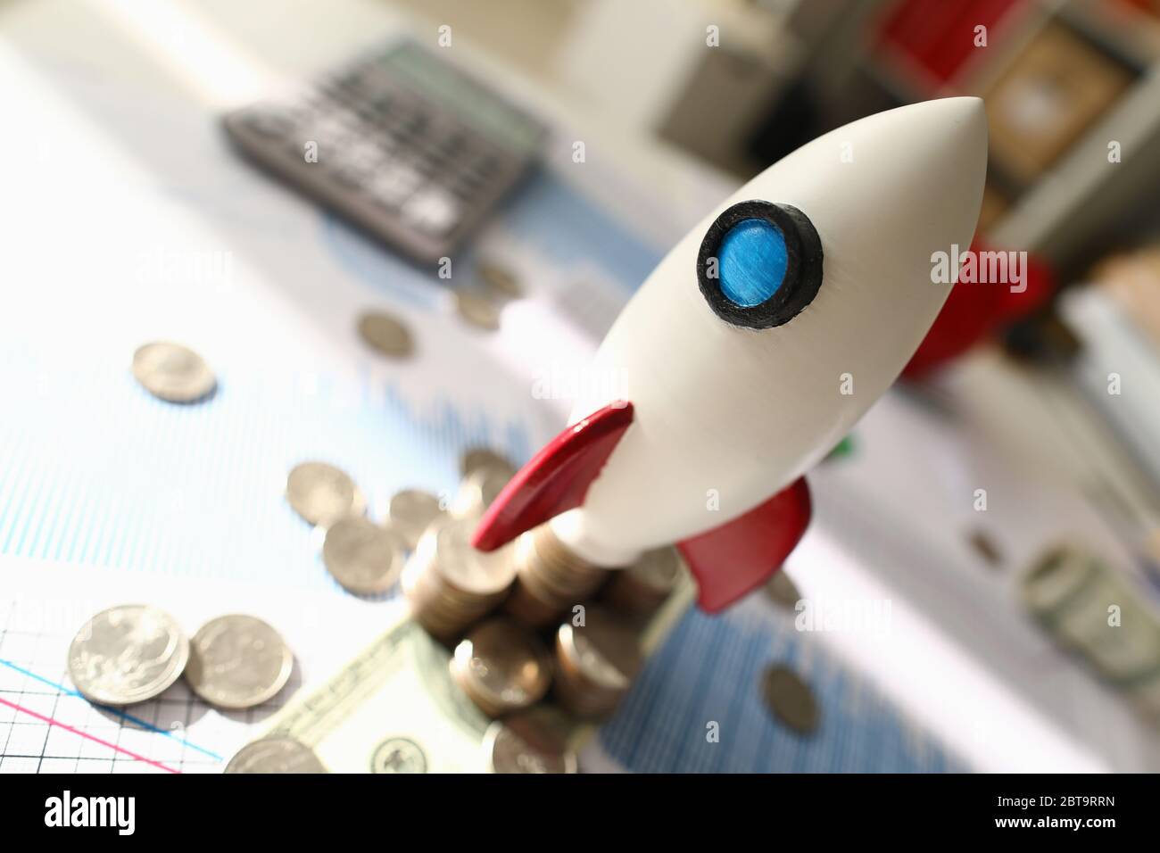 Space Rakete Modell steht auf Dokument in der Nähe von Münze Stockfoto