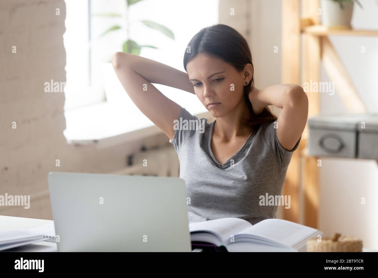 Müde Millennial Mädchen erschöpft von Hausaufgaben oder Studium Stockfoto