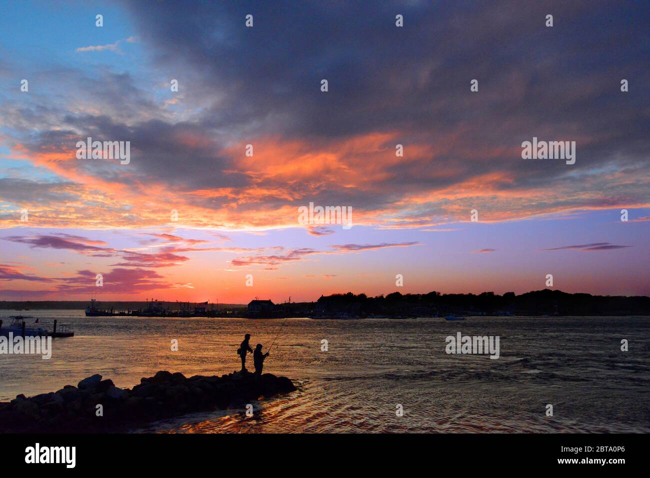 Jaging the Blues, zwei Männer in Westport Harbor für Blue Fish bei Sonnenuntergang in Westport Ma USA Foto von Bill belknap Stockfoto
