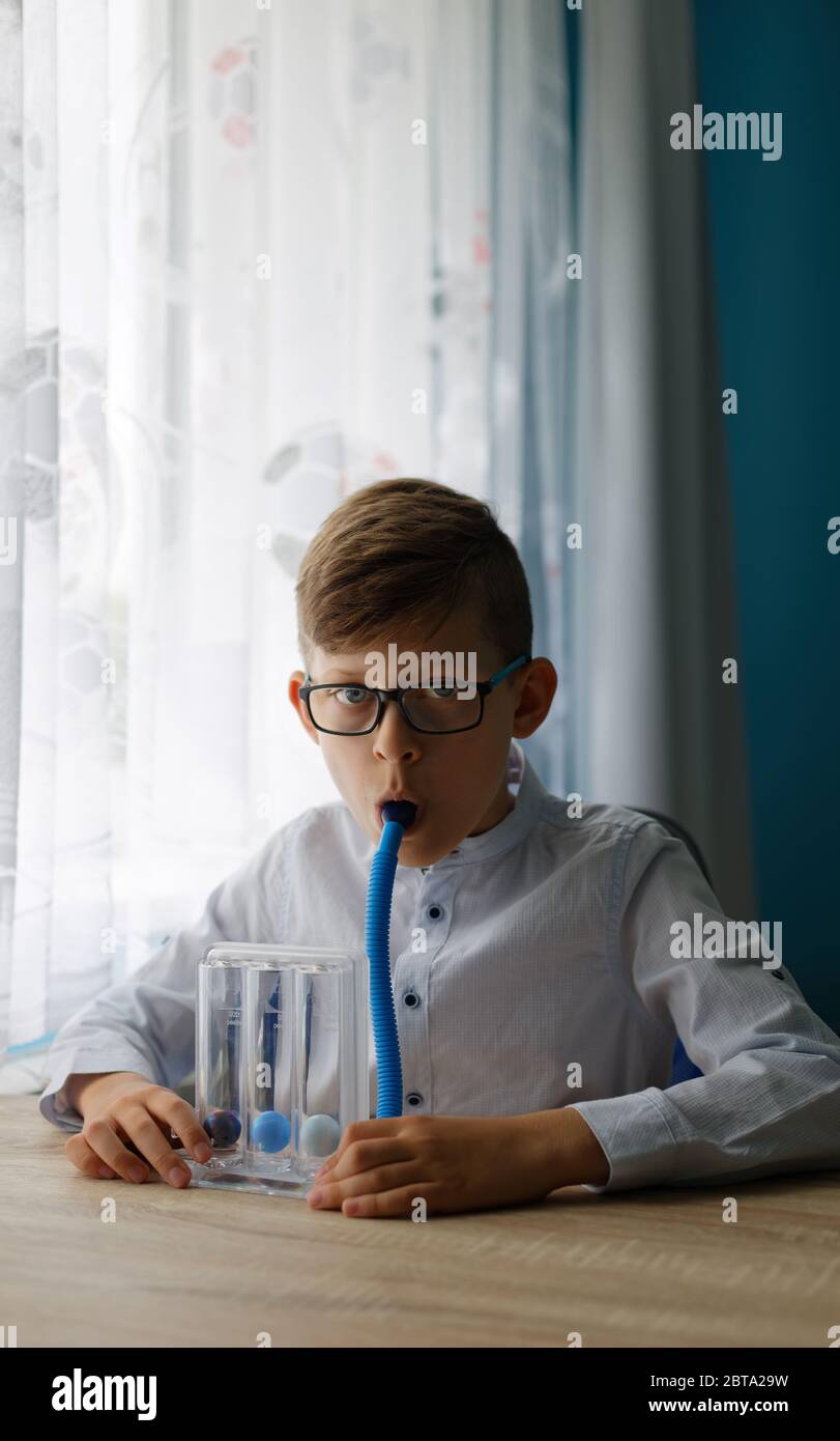 Junge kaukasische Junge tiefe Atmung Übung mit Spirometer. Atemübungen zur normalen tiefen Atmung Stockfoto