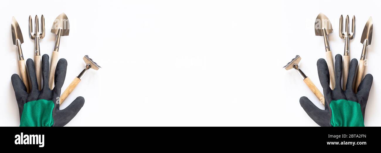 Gartenarbeit zu Hause. Anbau von Lebensmitteln auf Fensterbank. Werkzeuge Handschuhe für den Landwirt. Copyspace für Text, Draufsicht. Flatlay auf weißem Holzhintergrund. Banner. Werkzeuge werden Stockfoto