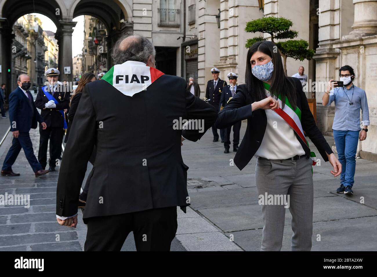 Turin, Italien – 24. April 2020: Chiara Appendino, die Bürgermeisterin von Turin, begrüßt mit dem Ellbogen ein Mitglied der Italienischen Föderation der Partisanen Verbände (FIAP), nachdem sie während der italienischen Widerstandsbewegung am Tag vor dem Tag der Befreiung einen Blumenkranz vor einer Tafel für militärischen Wert der Stadt Turin gelegt hatte. Am 25. April ist der Tag der Befreiung Italiens von den nazis und Faschisten und das Ende des Zweiten Weltkriegs für Italien. Die wiederkehrende Demonstration und Fackelzug werden aufgrund der COVID19-Beschränkungen nicht gefeiert. Quelle: Nicolò Campo/Ala Stockfoto