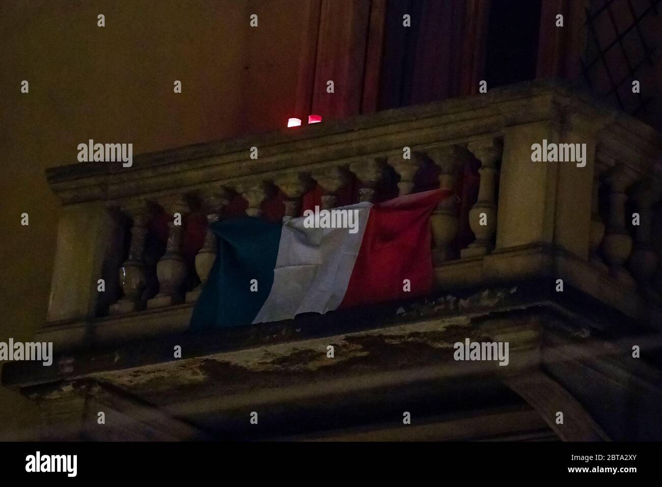 Turin, Italien - 24. April 2020: Zwei Kerzen und eine italienische Flagge werden auf einem Balkon gesehen, um den Tag der Befreiung zu feiern. Am 25. April ist der Tag der Befreiung (Festa della Liberazione), der die Befreiung Italiens von den nazis und Faschisten und das Ende des Zweiten Weltkriegs für Italien markiert. Die wiederkehrende Fackelprozession und Demonstration werden aufgrund der COVID19-Beschränkungen nicht gefeiert. Quelle: Nicolò Campo/Alamy Live News Stockfoto