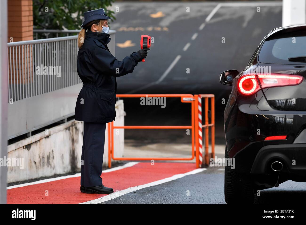 Turin, Italien - 29. April 2020: Ein Mitarbeiter wird bei der Ankunft mit dem Auto im Werk Mirafiori (Fiat Chrysler Automobiles) auf Temperatur geprüft. Das Werk von FCA Mirafiori in Turin nahm am 27. April die Produktion wieder auf. Italien wird weiterhin gesperrt, um die Ausbreitung des COVID-19-Coronavirus-Ausbruchs zu stoppen, aber die italienische Regierung setzt die Beschränkungen langsam zurück. Quelle: Nicolò Campo/Alamy Live News Stockfoto