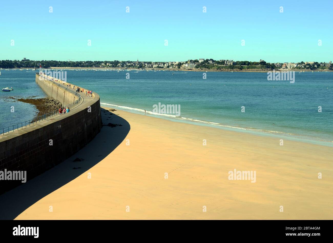 Morgenspaziergänge an der Wand, die einen der Strände von Saint Malo begrenzt Stockfoto