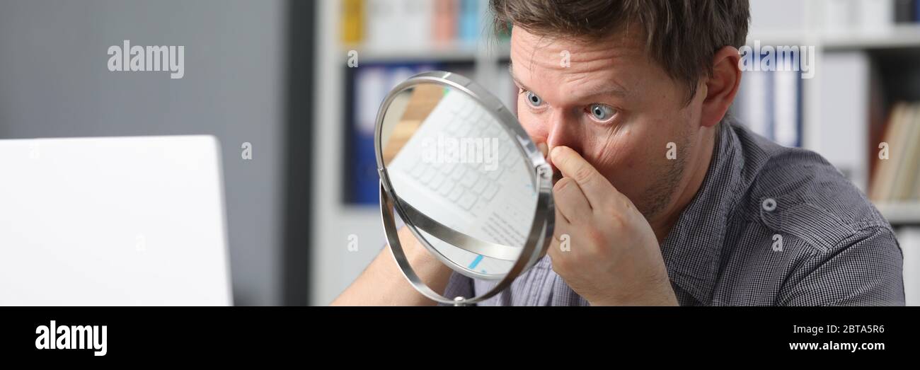 Der Mann versucht, den Hautzustand allein zu verbessern. Stockfoto