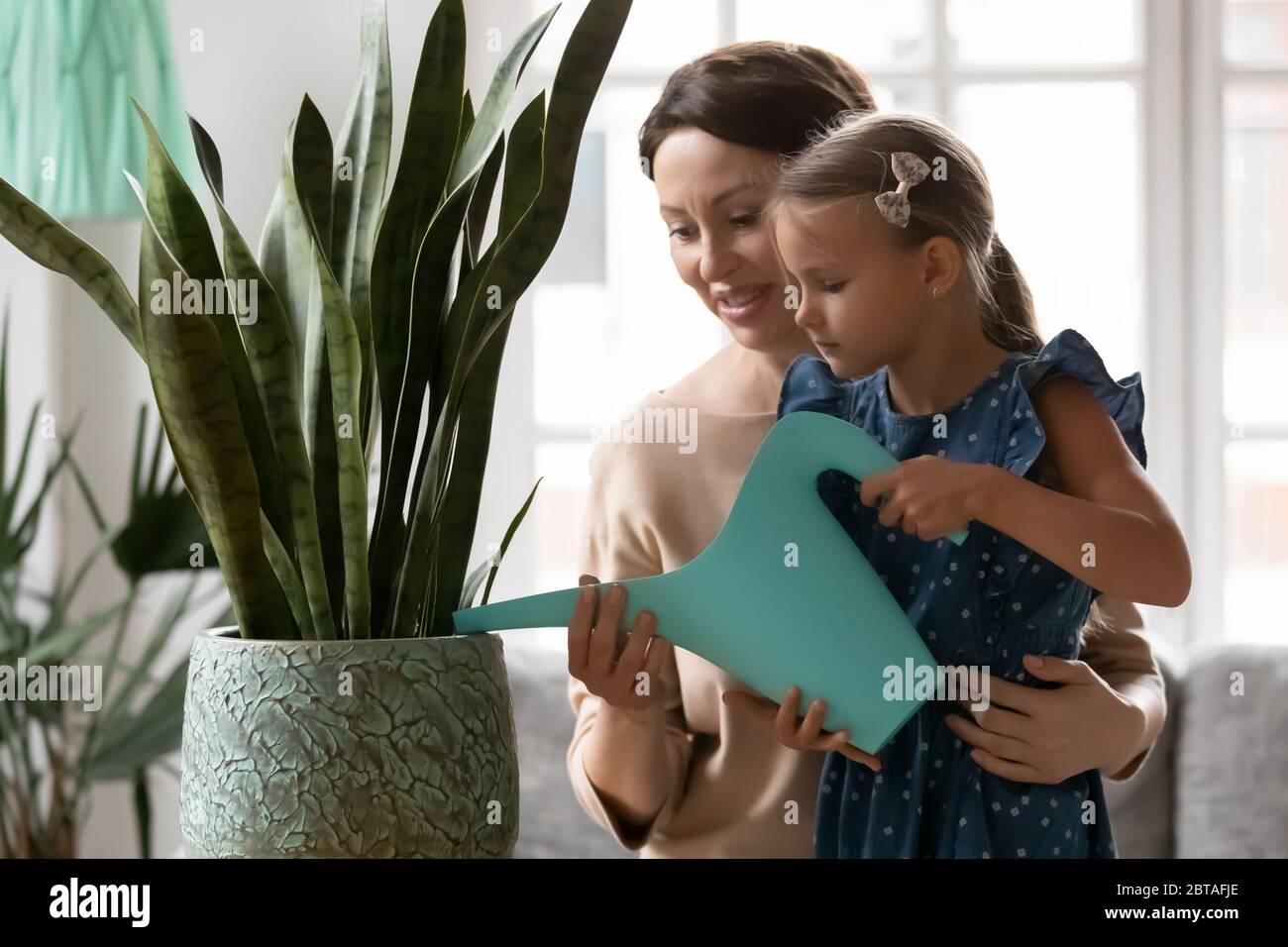 Ältere Großmutter und kleine Enkelin Bewässerungsanlagen Stockfoto