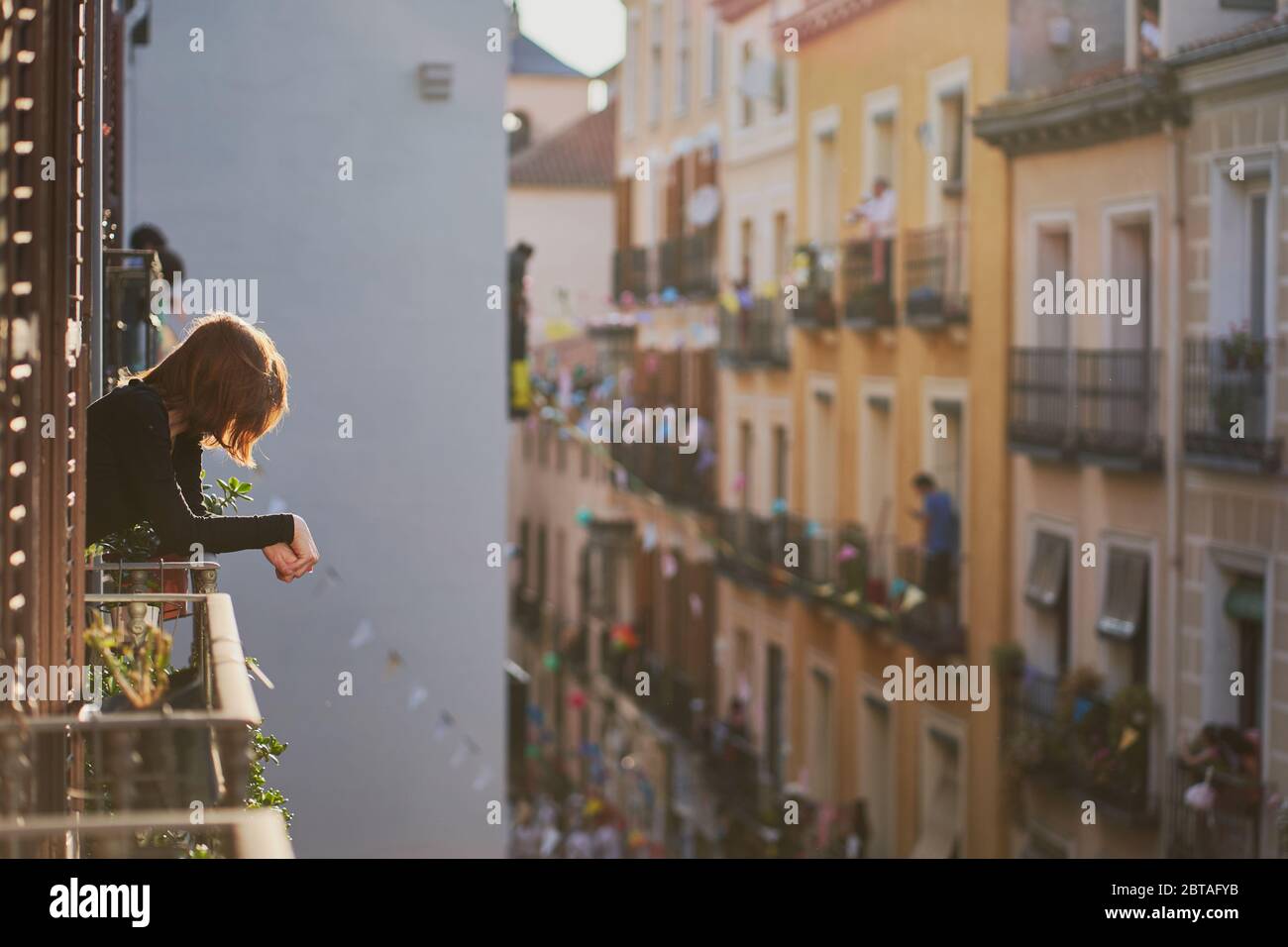 Eine Frau schaut aus ihrem Balkonfenster auf den Applaus/die Party für Rettungskräfte in Spanien um 20 Uhr. Aufgenommen während der Sperrung von Covid-19 in Madrid Mai 2020 Stockfoto