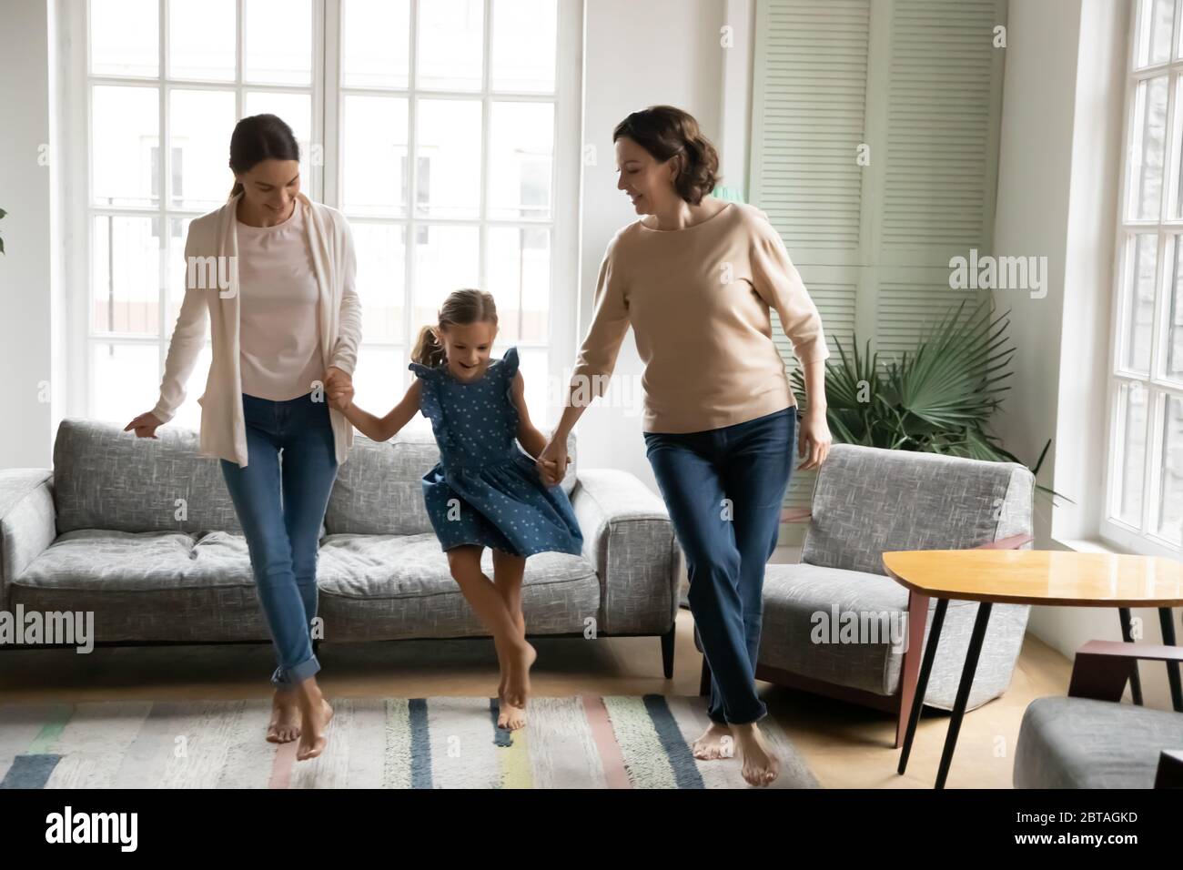 Energiegeladen drei Generationen von Frauen tanzen zu Hause Stockfoto