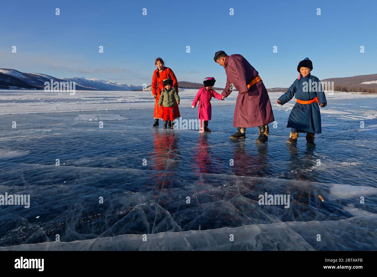 KHATGAL, MONGOLEI, 2. März 2020 : EINE mongolische Familie, in traditioneller Kleidung gekleidet, geht auf dem gefrorenen See spazieren. Stockfoto