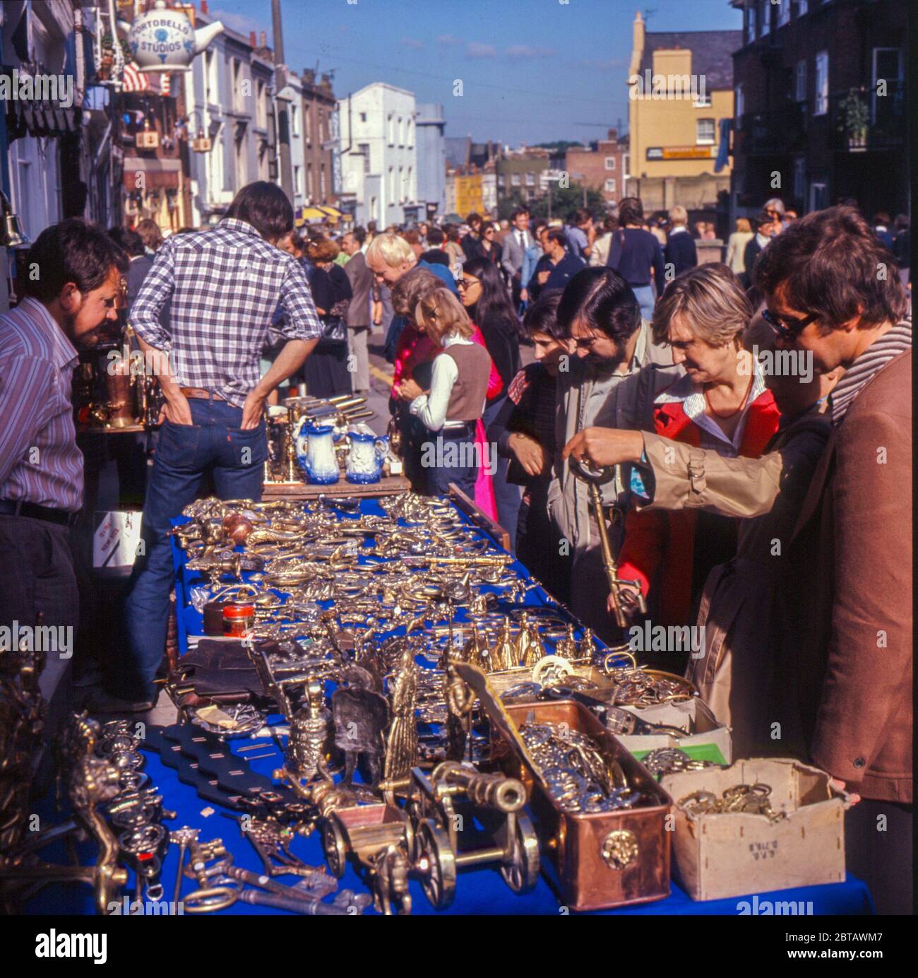 Touristen, Händler und Sammler stöbern in den 1970er Jahren in der Portobello Road im Londoner Nottiing Hill in den Antiquitäten und Kuriosen der Tischkiste Stockfoto