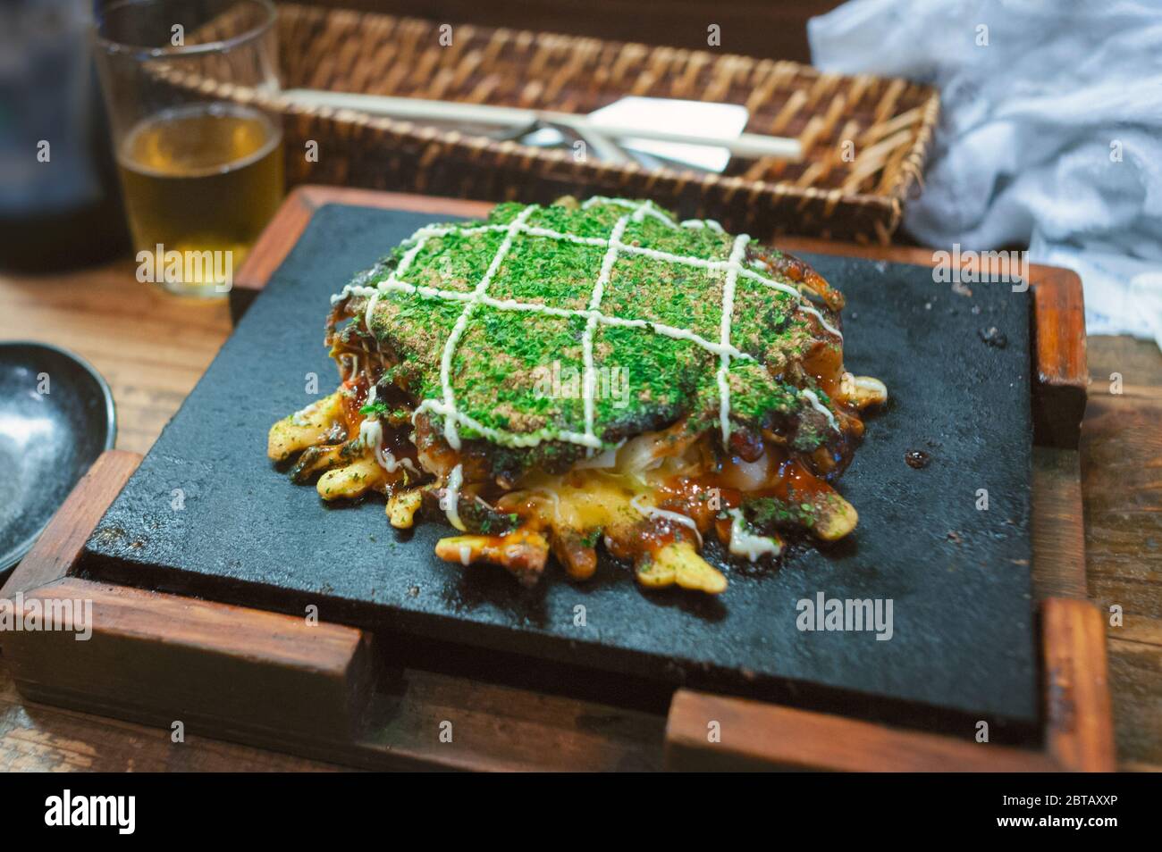 In Osaka, japanisches Soul Food aus der Region Kansai, ist das Okonomiyaki eine Pizza oder ein Pfannkuchen-Gericht, das mit Kohl, Algen, Mayonnaise und Reismochi gegrillt wird Stockfoto