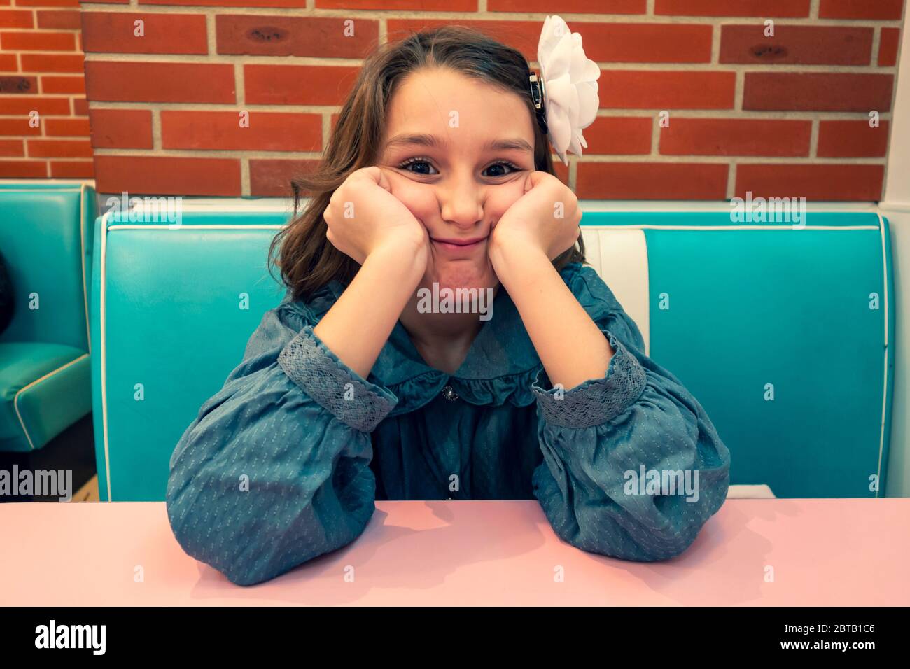 Junges Mädchen sitzt in einem Burger-Restaurant (HD Diner in Paris, Frankreich) Stockfoto