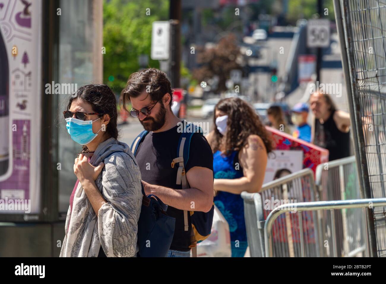 Montreal, CA - 23. Mai 2020: Menschen, die auf den Bus warten, einige von ihnen tragen Gesichtsmasken zum Schutz vor COVID-19 Stockfoto
