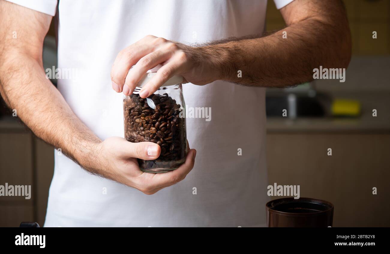 Mann hält Kaffeebohnen Glas Nahaufnahme. Lifestyle-Konzept für den Barista im Haus Stockfoto