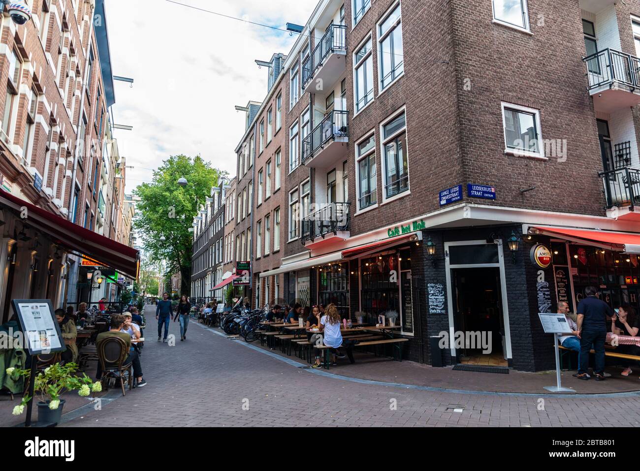 Amsterdam, Niederlande - 9. September 2018: Straße mit Menschen auf der Bar und Restaurant Terrassen in der Altstadt von Amsterdam, Niederlande Stockfoto