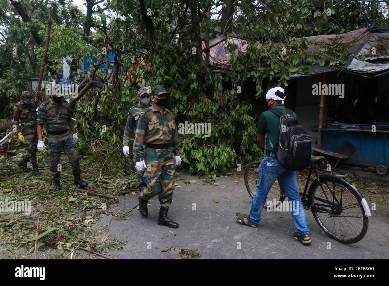 Kalkutta, Indien. Mai 2020. Armee Jawans arbeiten, um entwurzelten Baum von einer Straße zu löschen, nachdem Zyklon Amphan die Region in Kolkata traf. Ein mächtiger Wirbelsturm riss durch das dicht besiedelte Küstengebiet Indien und Bangladesch, sprengt Dächer und peitscht Wellen, die Böschungen und Brücken verschluckten und ganze Dörfer ohne Zugang zu Frischwasser, Strom und Kommunikation ließen. (Foto von Dipa Chakraborty/Pacific Press/Sipa USA) Quelle: SIPA USA/Alamy Live News Stockfoto