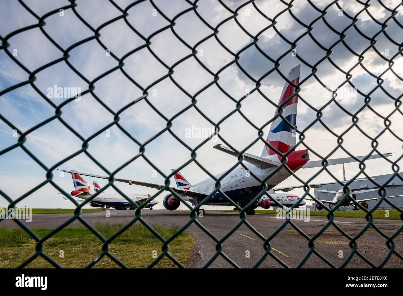 Durch einen Zaun gesehen, werden British Airways-Flugzeuge am Flughafen Cardiff geparkt, während sie während der Covid-19-Krise ungenutzt bleiben. Stockfoto