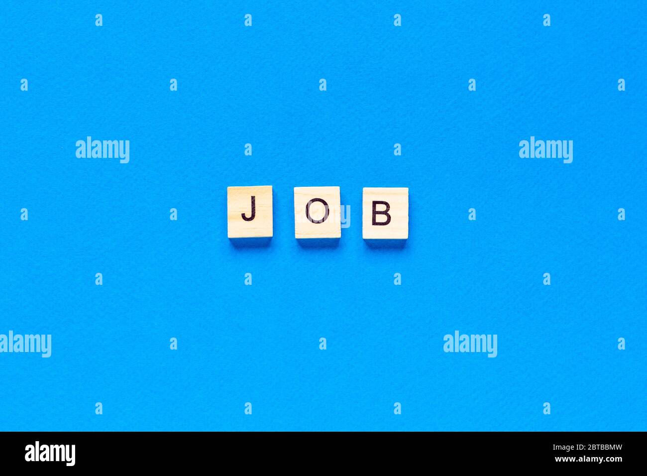 Word JOB mit Holzbuchstaben auf blauem Hintergrund gemacht. Berufskonzept. Job-Schriftzug in Holzbuchstaben auf blauem Hintergrund, flaches Layout, Draufsicht Stockfoto