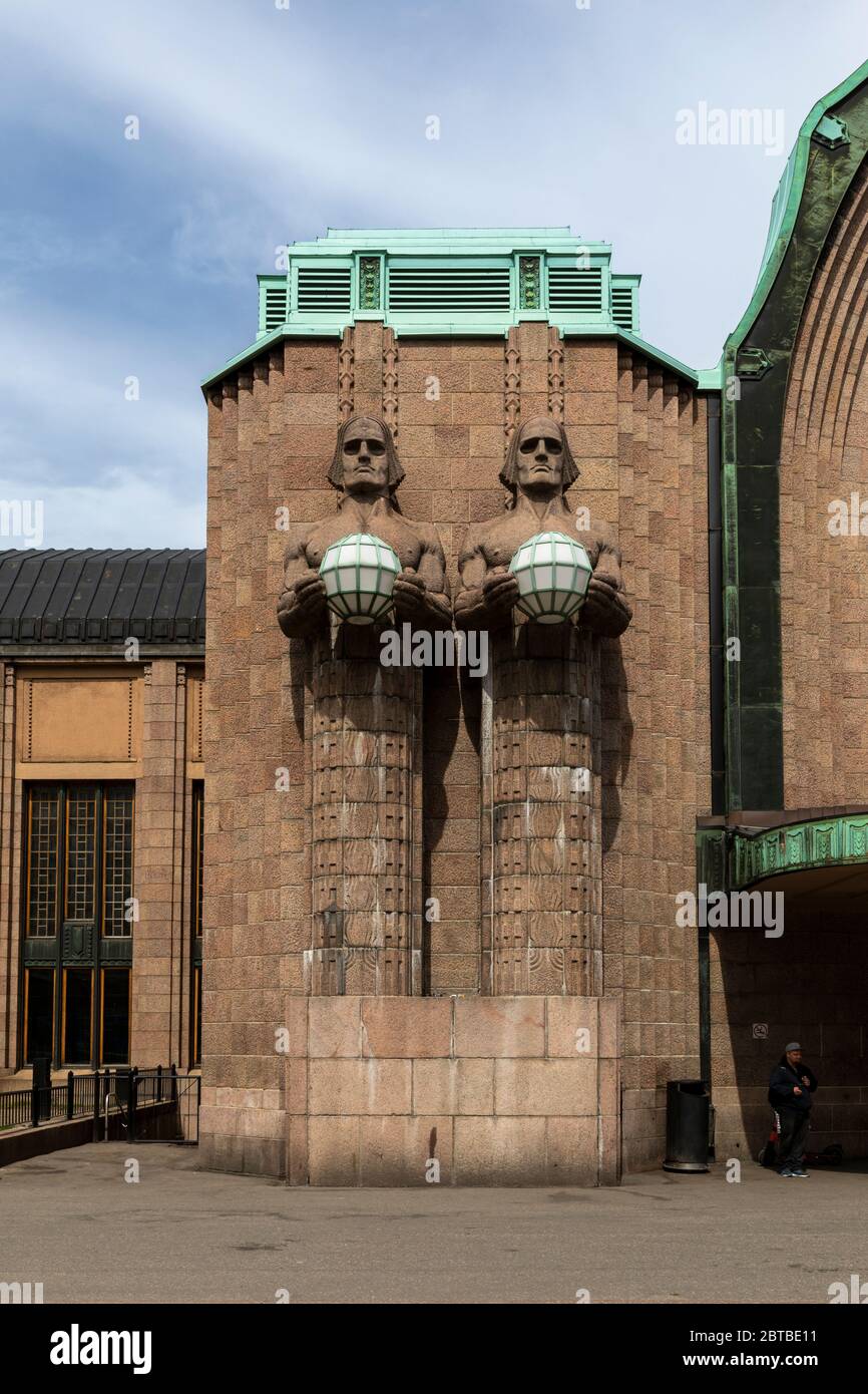 Der Hauptbahnhof Helsinki ist berühmt für vier Steinfiguren, die Lichtgloben tragen. Zwei Figuren sind auf jeder Seite des Haupteingangs. Stockfoto