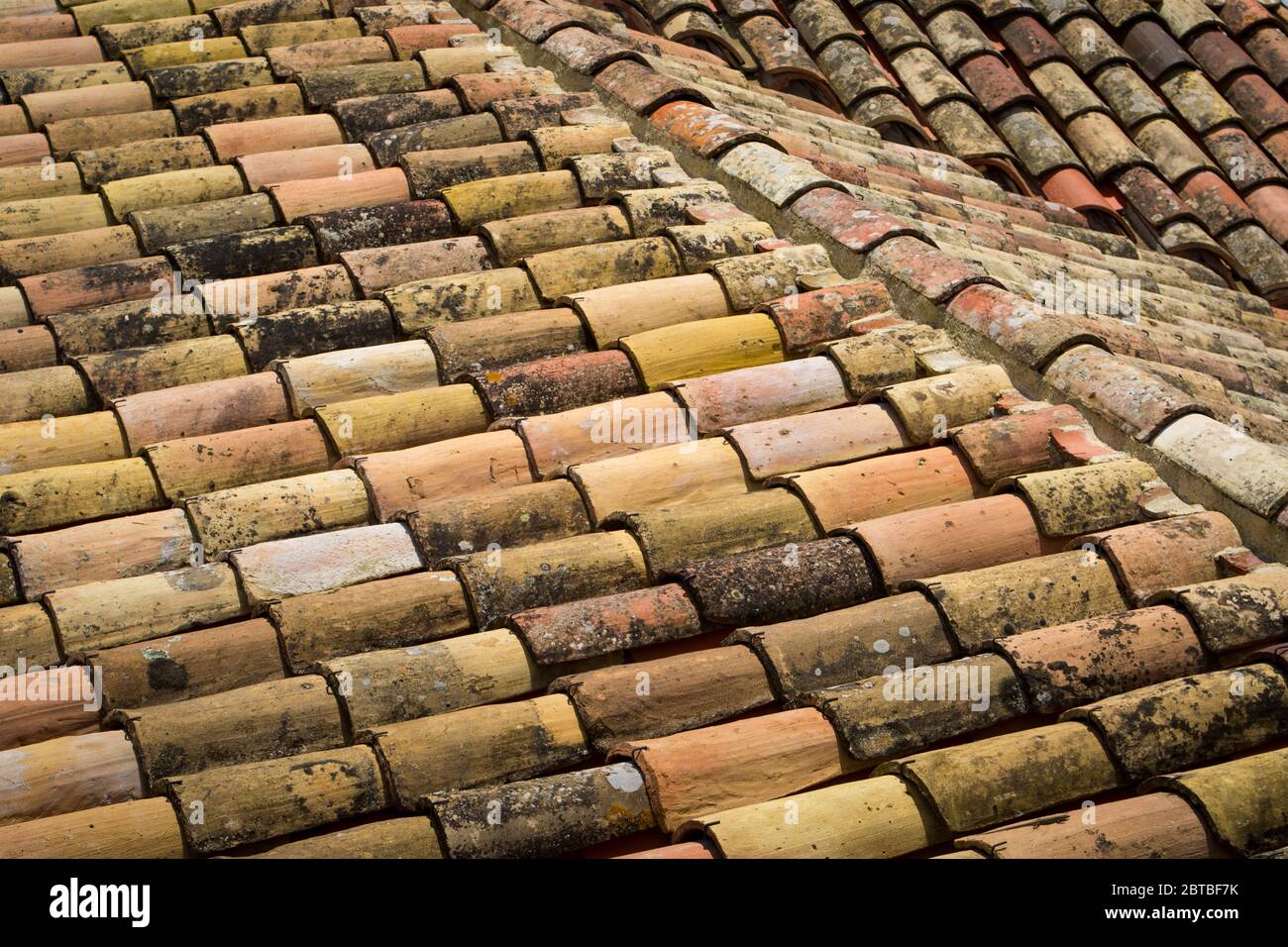Verwitterte Lehmschindeln auf einem alten europäischen Dach im Süden Frankreichs. Stockfoto