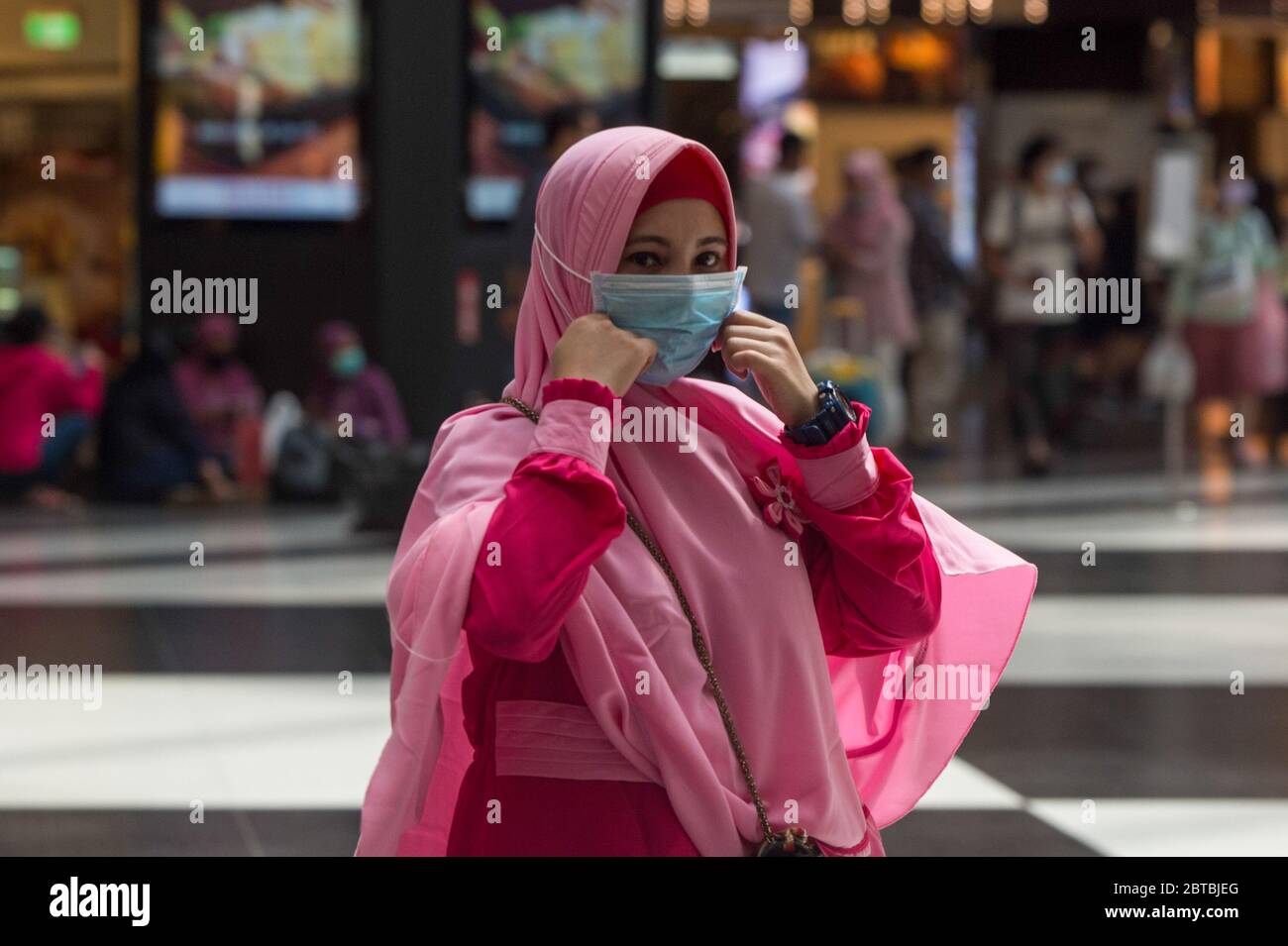 Eine muslimische Migrantin, die eine Gesichtsmaske trägt, um vorsichtshalber während der Feierlichkeiten am Hauptbahnhof Taipei entlang zu gehen. Eid Al-Fitr, das das Ende des Ramadan markiert, wurde der heilige Fastenmonat inmitten von Beschränkungen wie verbotenen Versammlungen in öffentlichen Bereichen wegen der Coronavirus-Pandemie gefeiert. Stockfoto